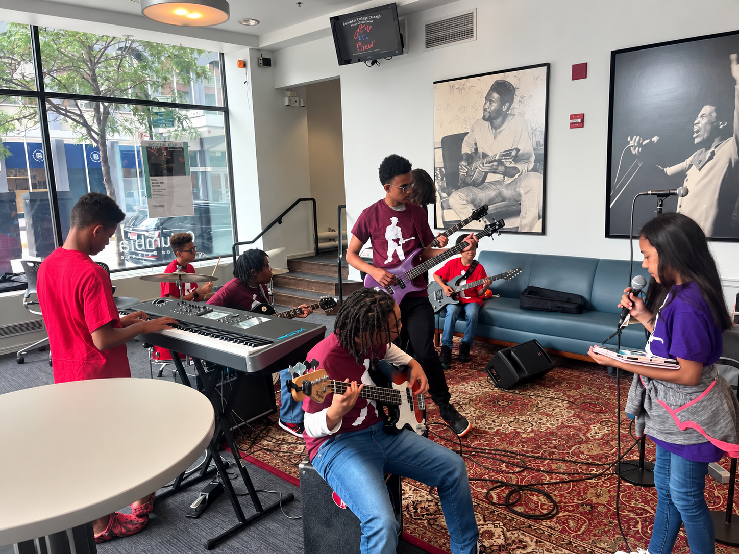 Young musicians rehearsing together on keyboards, drums, guitars, bass and vocals
