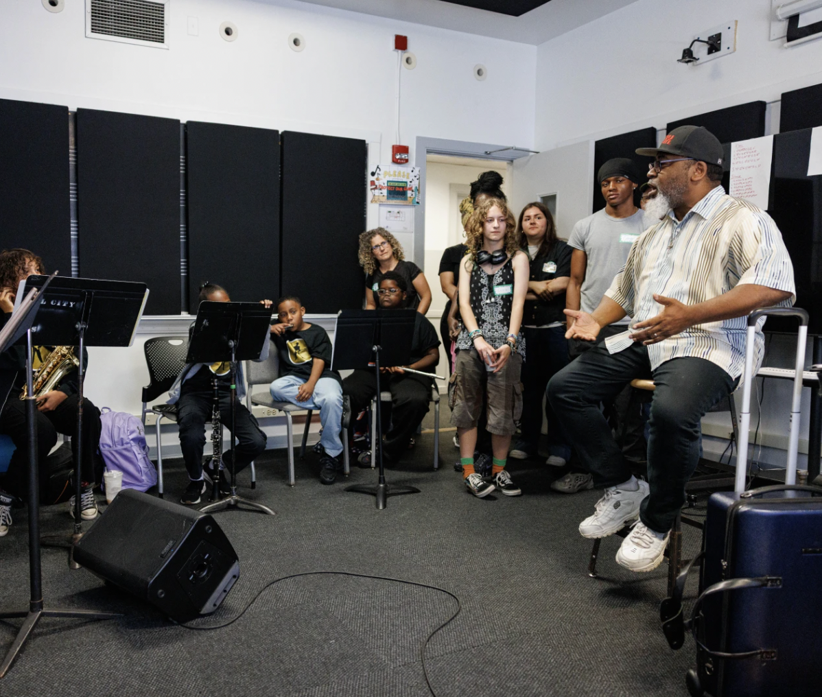 A Blues teaching artist speaking with young musicians during an ensemble workshop