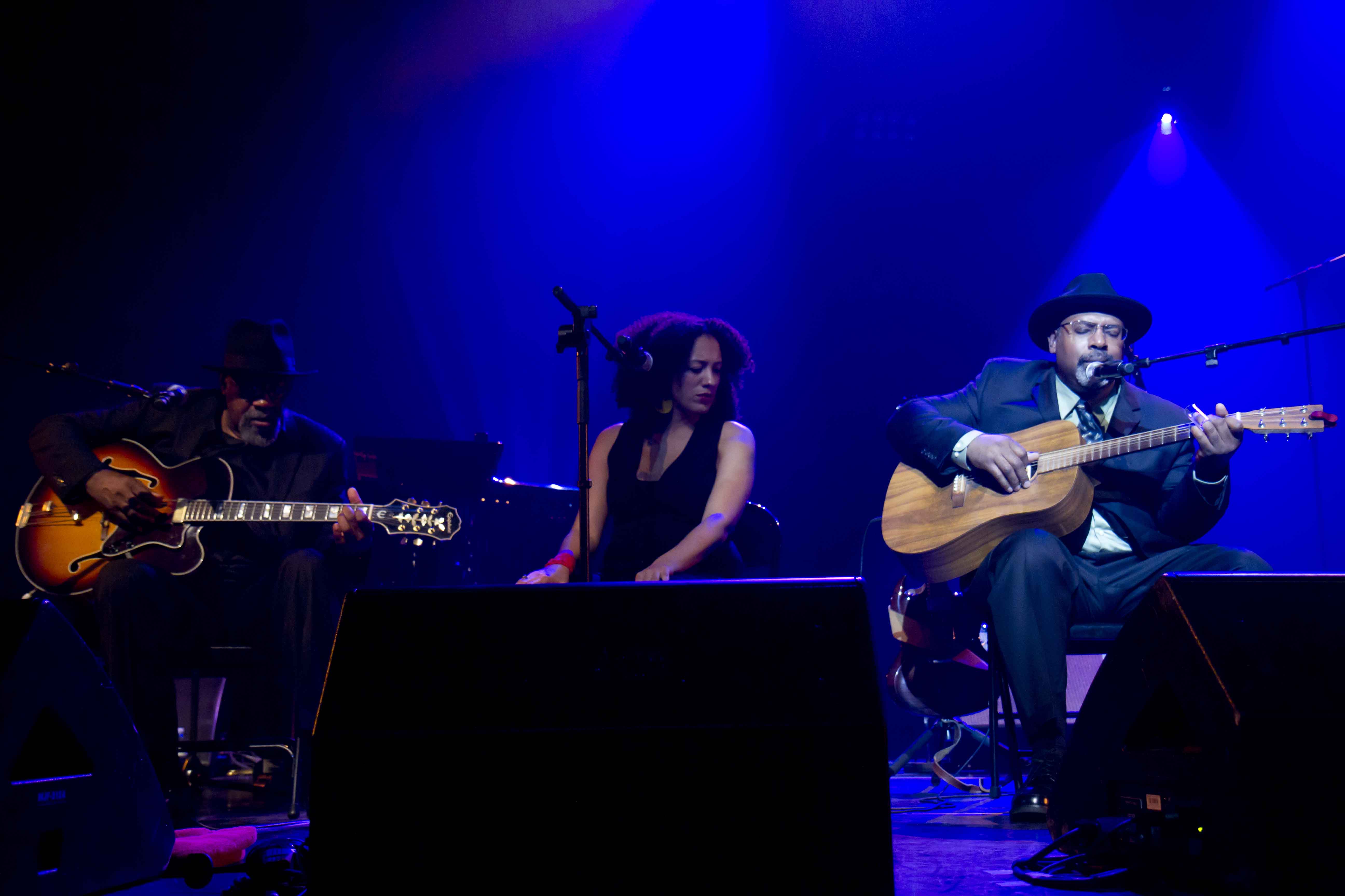 Heritage Blues Orchestra performing together under blue stage lights